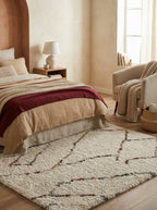 Tapis berbère crème Arles sous un lit, chambre chaleureuse beige et terracotta