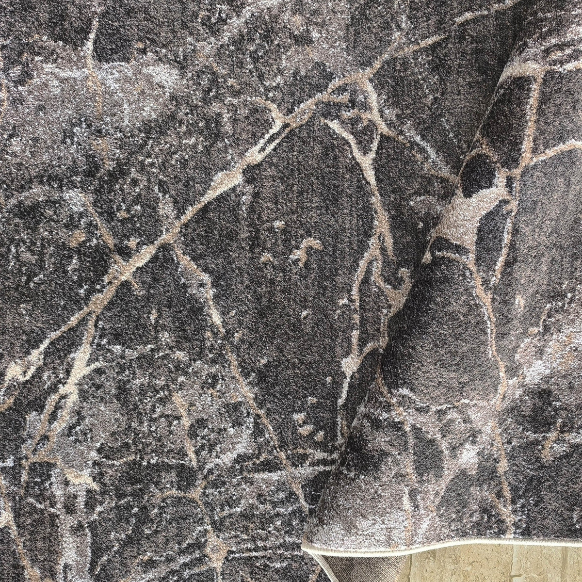 Gros plan sur les veines beige et crème du tapis Rhône, bord retourné