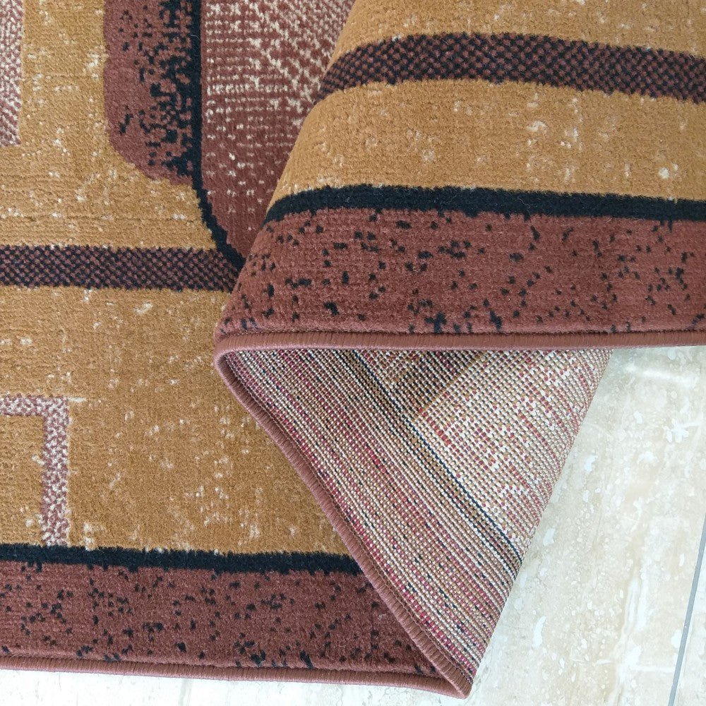 Coin plié du tapis Menton montrant la bordure chocolat et l'envers