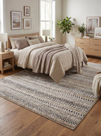 Tapis rayé chiné Céret sous un lit en bois dans une chambre aux tons naturels