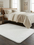 Tapis shaggy Vence sous un lit en bois sur parquet foncé