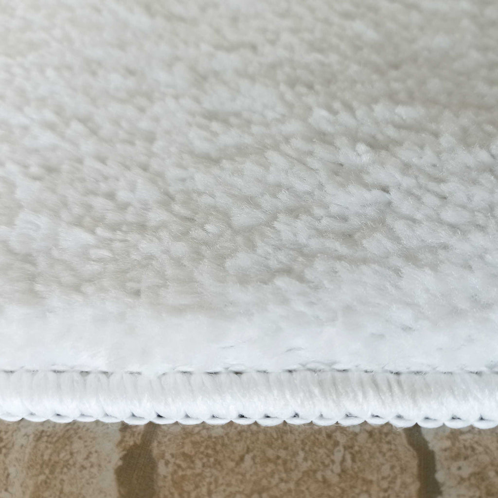 Finition surjetée blanche du tapis Vence